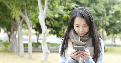 Woman Using Smart Phone in Urban Park