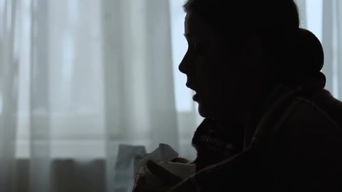 L'ombre d'une fille éternuant souffrant de la grippe saisonnière se réchauffe dans une couverture pour récupérer