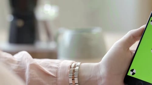 Woman holding phone with green screen