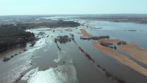The Camera Flies Forward High Above the Overflowing River in Spring