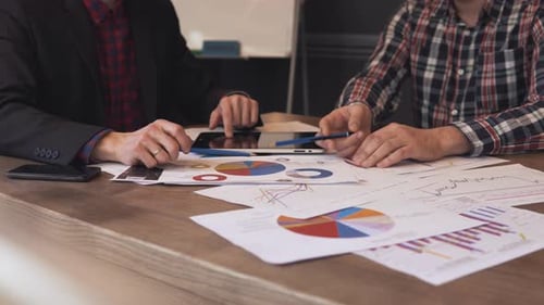 Deux hommes d'affaires analysent les graphiques