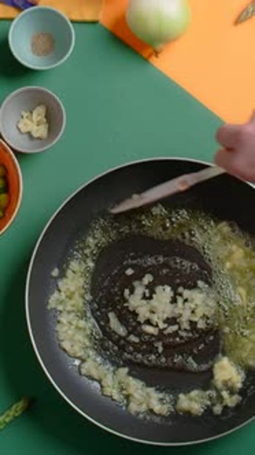 Vertical Video Recipe Chef Fries Chopped Onion in Butter on the Hot Pan