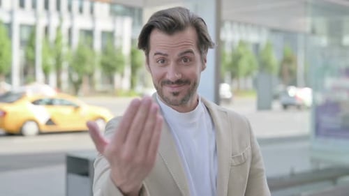 Friendly Man Invites Viewer Closer Outdoors