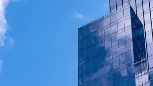 Time lapse of cloud with blue sky and windows reflection in high building