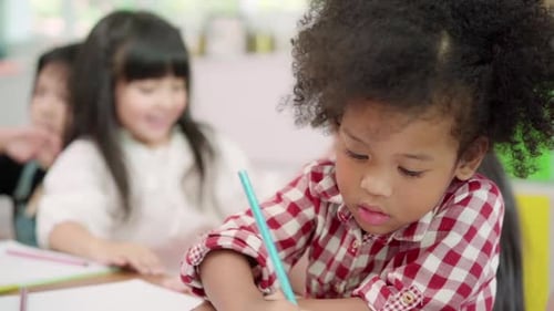 Multi-ethnic young boys and girls happy funny study and play painting on paper at elementary school.