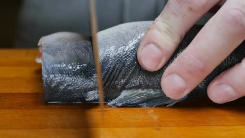 Slicing Fresh Raw Fish on Cutting Board