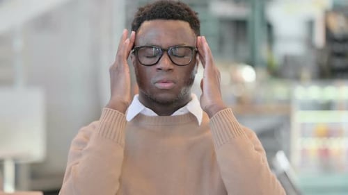 Young Adult Rubbing Head to Depict Headache