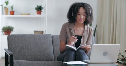 Woman Studying With Laptop and Notebook at Home