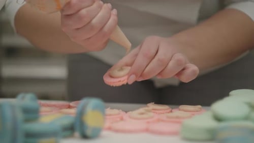 Hands Filling Colorful Macarons With Cream