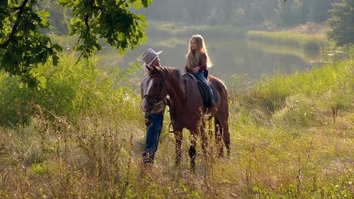 Girl Riding Horse with a Man by the Lake