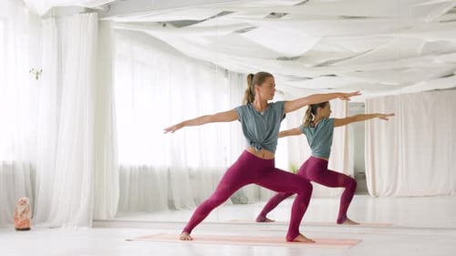 Frau macht Yoga-Krieger-Pose im Studio