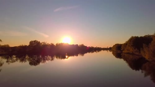 The Drone Flies Over a Beautiful Summer Landscape with a River at Sunset
