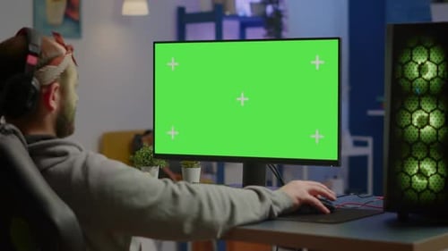 Gamer Playing Video Games on Powerful Computer with Green Screen Desktop