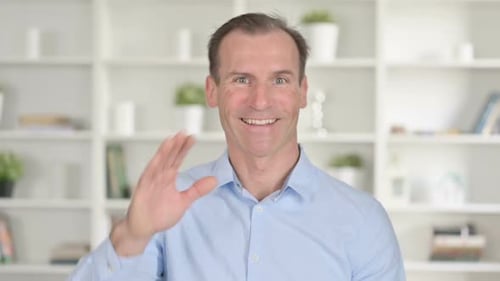 Man Smiling, Waving, and Clapping at the Camera
