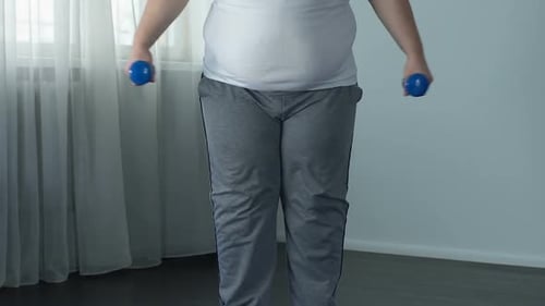 Man Lifting Dumbbells Indoors for Workout