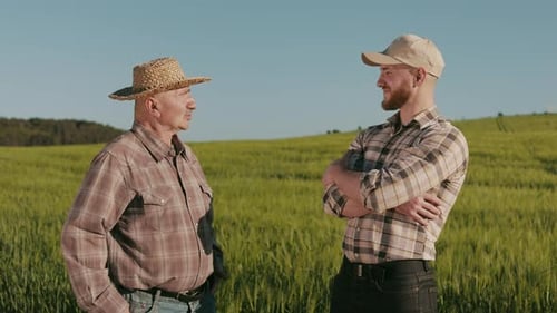 Two Farmers are Standing By the Field and Talking