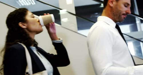 Workers Ride Escalator in Modern Office Building