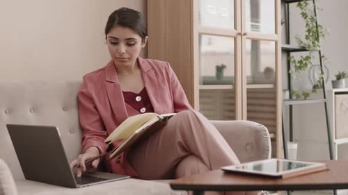 Geschäftsfrau gemischter Rassen arbeitet am Laptop und macht sich Notizen