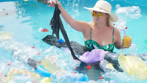 Konzept der Umweltverschmutzung des Planeten. Junge schockierte Frau schwimmt im Müll