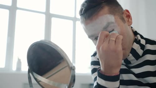 Young Adult Applying White Clown Makeup