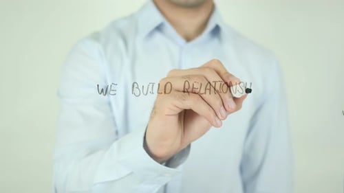 We Build Relationships, Man Writing on Screen