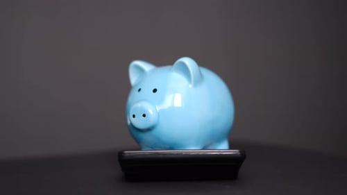 Piiggy Bank with Calculator Closeup on Blackl Background