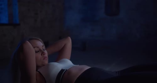 Fitte blonde Frau macht Bauchmuskelübungen auf Fitball und beugt Bauchmuskeln während des Trainings in Urban