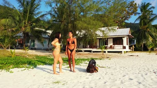 Sexy beauty models on photoshoot having fun at the beach on paradise white sand and blue background