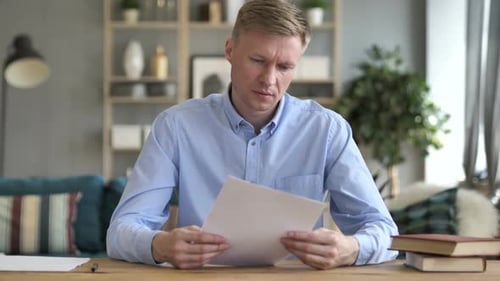 Geschäftsmann liest Dokumente bei der Arbeit (Vertrag)