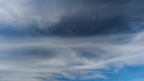 Différents types de nuages dérivent en même temps sur le ciel bleu.