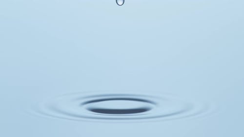 Water Droplets Ripple on Light Blue Background