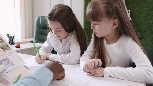 African American Teacher Teaching English Two Primary School Girls