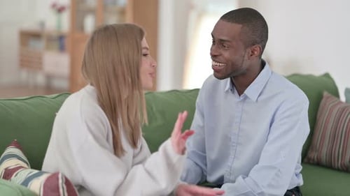 Couple métisse ayant une conversation à la maison