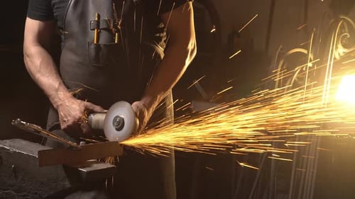 Metalworker Grinding Metal Creates Shower of Sparks