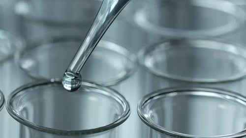 Dropping Clear Liquid into Test Tubes Close Up