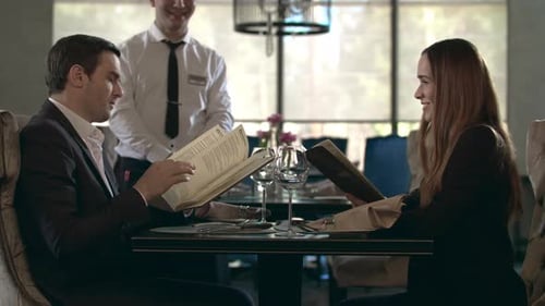 Happy Couple Reading Menu in Restaurant. Business People Choosing Food in Cafe