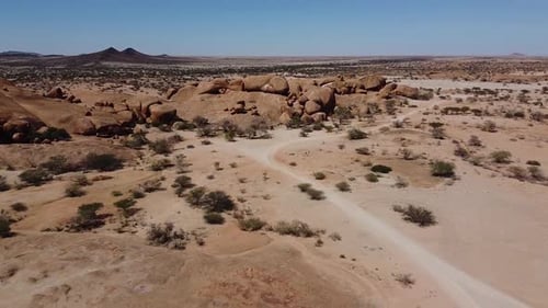 Drone view on a desert with massive rocks and lots of desert plants, Namibia