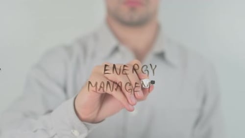 Man Writes Energy Management on Clear Surface
