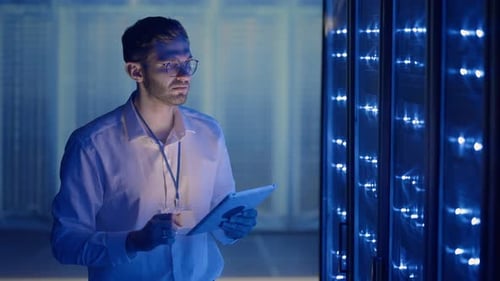 IT Technician in Data Center Digital Server Room Controlling Work of Rack Server Cabinets with a