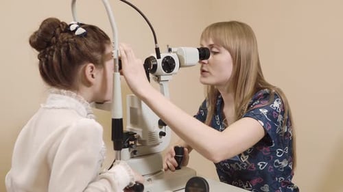 Young Girl Having Eye Exam by Doctor