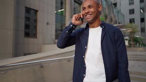 Happy Ethnic Guy Speaking on Smartphone on Street