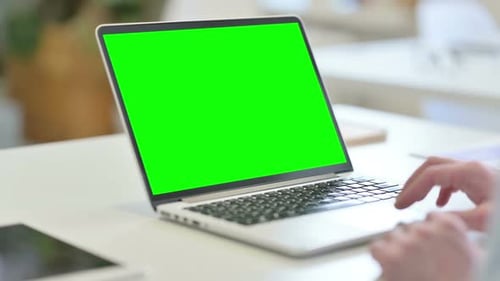 Rear View of Young Man Using Laptop with Chroma Screen