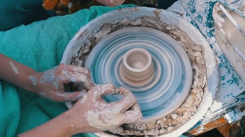 Les mains de potier travaillent avec de l'argile sur un tour de potier