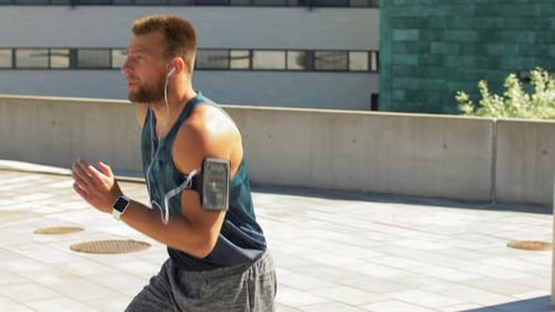 Young Man in Earphones Running Upstairs Outdoors