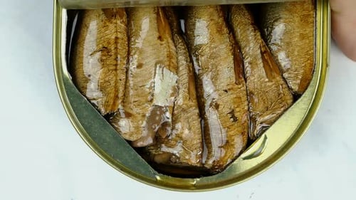 Opening a tin of smoked fish close up