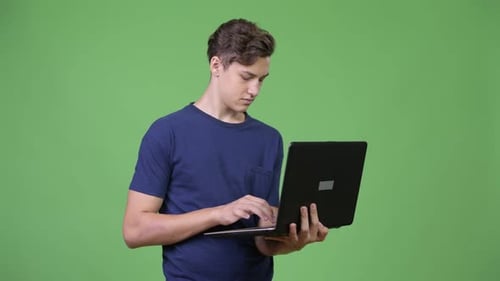 Young Man Typing on Laptop Computer