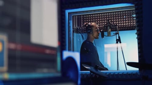 Male Rap Singer with Headphones and Sound Engineer Are Recording a New Song