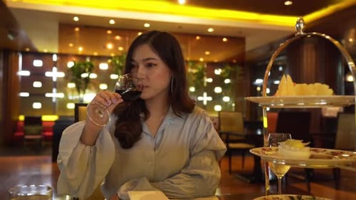 young woman drinking wine in the restaurant