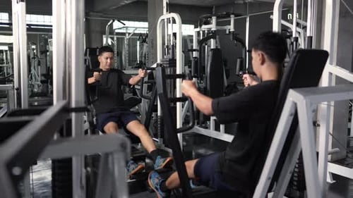 4K Asian athlete man workout exercise on weight lifting machine at fitness gym.