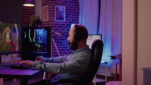 Man Plays Video Game on Computer at Night